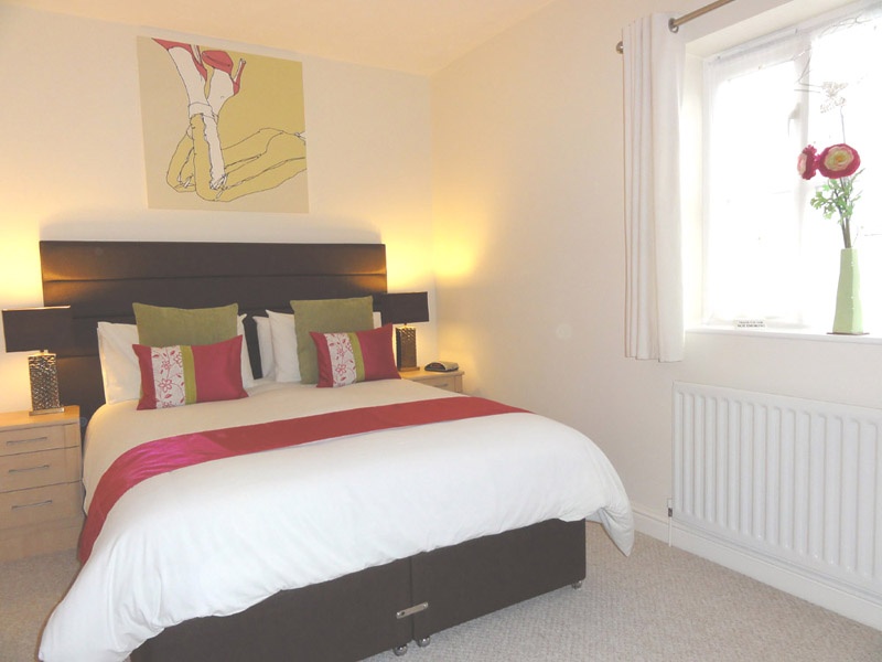 there is a king sized divan bed with mirrored wardrobes in back bedroom of holiday cottage